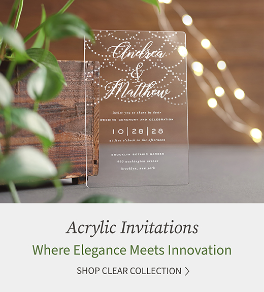 A crystal clear wedding invitation is shown with twinkling lights in the background.